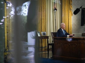 Visto a través de una ventana, el presidente Joe Biden se dirige a la nación sobre el acuerdo presupuestario que eleva el límite de la deuda federal y evita el incumplimiento del gobierno de EE. UU., desde la Oficina Oval de la Casa Blanca en Washington, el viernes 2 de junio de 2023.