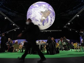 FILE - Delegates gather inside the venue on another day at the COP26 U.N. climate summit in Glasgow, Scotland, Wednesday, Nov. 3, 2021. A senior United Arab Emirates official says the Gulf nation wants the U.N. climate summit it's hosting later this year to deliver "game-changing results" for international efforts to curb global warming, but doing so will require having the fossil fuel industry at the table.