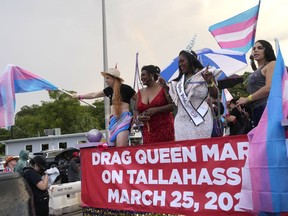 Nic Zantop, left, waves a transgender flag while on a float sponsored by several transgender groups, with Tiffany Arieagus, second from left, and Miss Naples Pride Velvet Lenore, second from right, during the Stonewall Pride Parade and Street Festival, Saturday, June 17, 2023, in Wilton Manors, Fla.