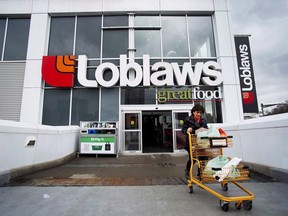 A woman carts out groceries from a Loblaws in Toronto. The Competition Bureau says the grocery industry needs more competition.