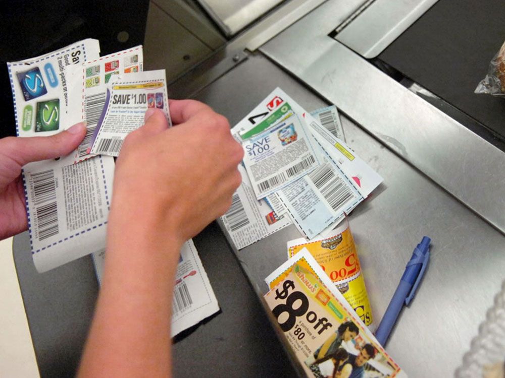 A shopper sorts through coupons at a check-out counter. Consumers need to allocate time, effort and funds to planning, budgeting and shopping during high inflation. 