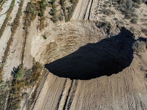 An aerial view of the large sinkhole that appeared near the Alcaparrosa mine operated by Canadian firm Lundin Mining Corp.