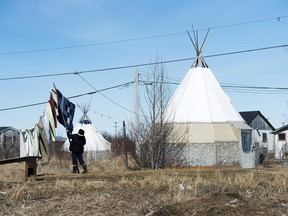 An Indigenous woman takes down laundry in the northern Ontario First Nations reserve in Attawapiskat, Ont.
