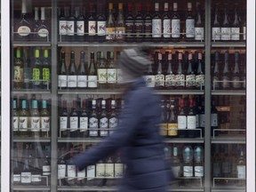 A person walks past shelves of bottles of alcohol on display at an LCBO in Ottawa.