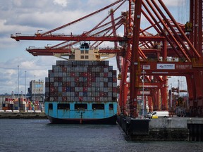 Cargo containers are unloaded from the Maersk Stockholm ship with gantry cranes while docked at port in Vancouver.
