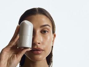 Hailey Rhode Bieber showcasing a product from her skincare brand Rhode.