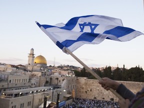 Israelis wave their national flags during a march next to the Western Wall in Jerusalem.