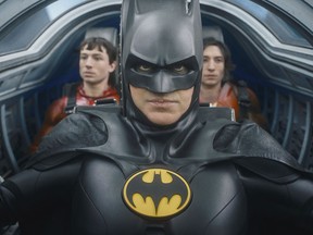 This image released by Warner Bros. Pictures shows Ezra Miller, from left, Michael Keaton and Ezra Miller in a scene from 