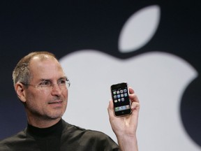 FILE - Apple CEO Steve Jobs holds up an Apple iPhone at the MacWorld Conference in San Francisco on Jan. 9, 2007. The iPhone introduced the convenience of touchscreens at the time that a physical keyboard was still all the rage on the top-selling smartphone – the BlackBerry – when Jobs first took out what was all-in-one computer, camera and music player out of his pocket in 2007.