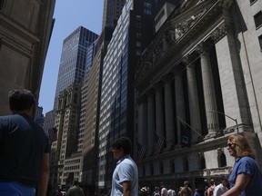 FILE-ニューヨーク証券取引所の前を歩く人々（2023年6月2日、ニューヨーク）。ウォール街は、世界の中央銀行と金利にとって重要な週を前に上昇している。S&P500種株価指数は、6月12日（月）早朝に0.2％上昇した。