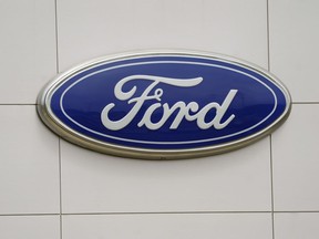FILE - The Ford logo is seen on signage at a Ford dealership, Tuesday, July 27, 2021. The National Highway Traffic Safety Administration is investigating a Ford Motor Co. recall of more than a quarter-million Explorer SUVs in the U.S. after receiving complaints about repairs intended to prevent the vehicles from unexpectedly rolling away even while placed in "park" gear.