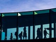 Office workers walk through a Plus 15 into The Bow office building in Calgary