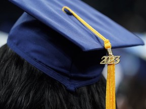 A graduation tassel with 2023 on it rests on a graduation cap.