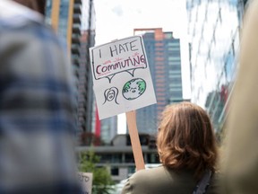 A demonstrator holds a sign that reads "I hate commuting" as Amazon employees and supporters gather during a walk-out protest against a return-to-office mandate, among other grievances, outside Amazon headquarters in Seattle, Wash. in May.