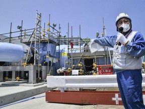 An employee of Tokyo Electric Power Company explains about the facility to be used to release treated radioactive water to media at Fukushima Daiichi nuclear power plant in Fukushima, northern Japan, Monday, June 26, 2023. All equipment needed for the release into the sea of treated radioactive wastewater from the wrecked Fukushima nuclear plant has been completed and will be ready for a safety inspection by Japanese regulators this week, the plant operator said Monday, as opposition to the plan continues in and outside Japan over safety concerns.(Kyodo News via AP)