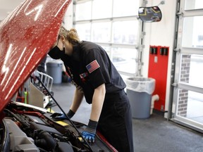 An employee works under the hood of a vehicle at a Valvoline Inc. Instant Oil Change location in Indianapolis, Ind.