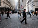 Les gens marchent le long de Wall Street près de la Bourse de New York.  Les chefs de Wall Street ont été parmi ceux qui ont le plus insisté pour un retour au bureau cinq jours par semaine.