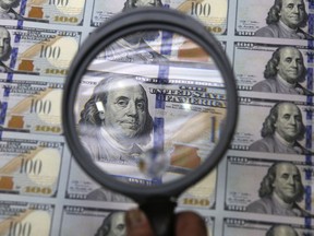 FILE - A sheet of uncut $100 bills is inspected during the printing process at the Bureau of Engraving and Printing Western Currency Facility in Fort Worth, Texas, on Sept. 24, 2013. More than $200 billion may have been stolen from two large pandemic-relief initiatives, according to a new estimates from a federal watchdog investigating federally funded programs designed to help small businesses survive the worst public health crisis in more than a hundred years.