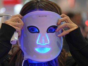 Kimberly Lafleur from LUSTRE ClearSkin wears the revive mask at the company booth during the CES tech show in Las Vegas, Friday, Jan. 6, 2023. One in 10 Canadians spend more than $500 on skin care every year, but it isn't as simple as opting out, especially for women.