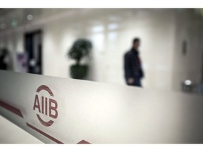The logo of the Asian Infrastructure Investment Bank (AIIB) is displayed at the bank's headquarters building in Beijing, China, on Thursday, Jan. 5 2017. One year after opening with 57 charter members, the China-led AIIB remains open to the U.S. joining, President Jin Liqun said. Photographer: Qilai Shen/Bloomberg
