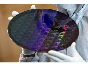 An employee carries a 300 millimetre silicon wafer at the Globalfoundries semiconductor fabrication (fab) plant in Dresdenin Germany, Dresden on Thursday August 12, 2021. Liesa Johannssen-Koppitz/Bloomberg