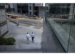 Pedestrians make their way through Central district in Hong Kong, China, on Wednesday, Aug. 18, 2021. Hong Kong is caught between its desire to reopen and the government's zero tolerance for any cases of Covid-19, which has kept the virus out for most of the pandemic. Photographer: Paul Yeung/Bloomberg
