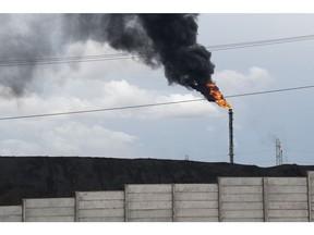 Gas flares behind a coking coal pile at the Jose Antonio Anzotegui Petrochemical Complex in Barcelona, Anzoategui state, Venezuela, on Monday, May 22, 2023. Venezuela's Oil ministry published oil and gas reserves for years 2019 through 2022, according to a decree in the official gazette dated May 9.