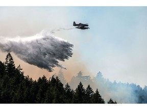 A fixed wing waterbomber drops water onto the Cameron Bluffs wildfire near Port Alberni, British Columbia, Canada, on Tuesday, June 6, 2023. Canada is on track to see its worst-ever wildfire season in recorded history if the rate of land burned continues at the same pace.
