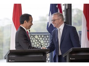 Jokowi shakes hands with Anthony Albanese at a news conference in Sydney.