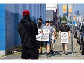 Dockworkers arrive to walk a picket line at the Port of Vancouver on July 5. Photographer: Jimmy Jeong/Bloomberg