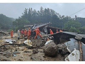 Emergency workers search for survivors at a house destroyed by flood waters after heavy rains in North Gyeongsang Province on July 15. Source: Handout/Getty Images AsiaPac
