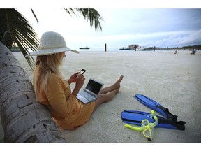 VILLINGILI, ADDU ATOLL , MALDIVES - SEPTEMBER 27: Woman sitting on Villingili beach, working with a notebook and mobile phone, surfing in the internet. The island is owned by the luxurious Shangri-La's Villingili Resort and Spa Hotel on September 27, 2009 in Male, Maldives.The maldive islands consist of around 1100 islands and 400000 inhabitants spread on 220 islands. Till 2008, between 30 years reign of Maumoon Abdul it was not allowed for tourists to visit local islands without special permission. Now from Villingili Island, tours are possible to visit the local islands of Addu Atoll.