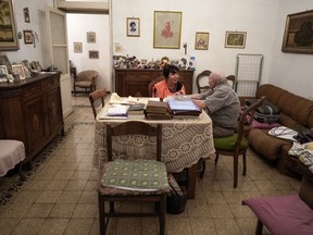 Sant'Egidio Catholic group volunteer Michela Tassani, left, chats with 98-year-old Armando Frajegari in his home, in Rome, Wednesday, July 19, 2023. As an intense heat wave with temperatures close to 40 degrees Celsius in many Italian cities is forcing elderly and fragile people to stay in their homes, Sant'Egidio volunteers check up on them providing company and helping in daily routines such as food shopping.