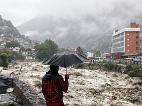 A man looks at a swollen River Beas following heavy rains in Kullu, Himachal Pradesh, India, Sunday, July 9, 2023. According to local reports heavy rain fall has triggered landslides, damaged houses and caused loss of lives.