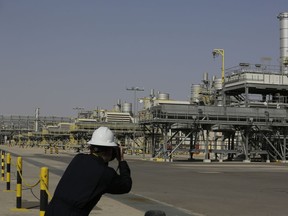 FILE - A photographer takes pictures of the Khurais oil field during a tour for journalists, 150 km east-northeast of Riyadh, Saudi Arabia, on June 28, 2021. Saudi Arabia and Russia are extending cuts to the amount of oil they pump to the world to try to prop up prices, showing how two of the world's largest oil producers are scrambling to boost income from the fossil fuel even as demand has weakened with the economy. The move Monday, July 3, 2023, gave a slight boost to oil prices and comes after the Saudis announced a large cut in output for July at the latest meeting of the OPEC+ coalition of oil producers.