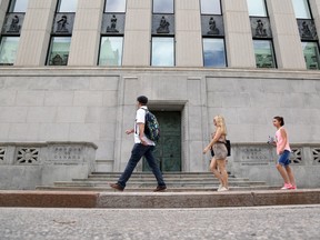 Pedestrians walk past the Bank of Canada building in Ottawa.