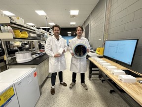SiPhox Health co-founders standing in the SiPhox Health biochip pilot line and lab space. CEO Diedrik Vermeulen (right) is holding a 12" silicon photonics wafer with SiPhox's sensor chips and CPO Michael Dubrovsky (left) is holding the SiPhox Home device.