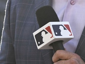 MLB broadcaster Mike Pomeranz holds a microphone before a baseball game between the Los Angeles Angels and the San Diego Padres on Monday, July 3, 2023, in San Diego. Major League Baseball's takeover of Padres' broadcasts involved months of planning, a playbook MLB is following this week with Arizona Diamondbacks' telecasts.