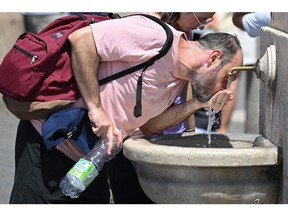 A man drinks water from a fountain in the Vatican on July 9  Photographer: Alberto Pizzoli/AFP/Getty Images