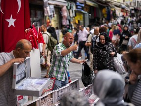 FILE - Sellers attend to customers in a street market in Eminonu commercial district in Istanbul, Turkey, on June 16, 2023. Turkey's central bank raised its key interest rate on Thursday July 20, 2023 to 17.5% in a further sign of commitment to orthodox economic policy following elections in May.