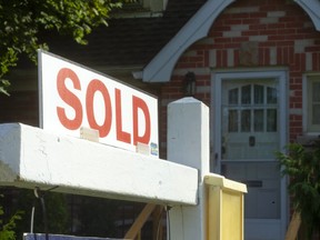 A "sold" sign outside a house.