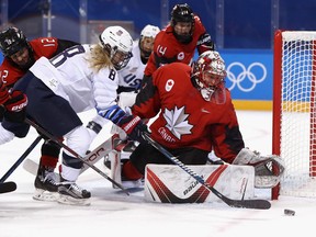 Goaltender Genevieve Lacasse looks to protect the puck at the net against fellow Professional Women's Hockey Players Association member Emily Pfalzer during the PyeongChang 2018 Winter Olympic Games in Gangneung, South Korea.