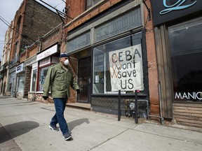 A closed store front boutique business called Francis Watson pleads for help displaying a sign in Toronto in 2020.