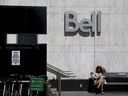 A woman reading outside a Bell Canada office in Toronto.