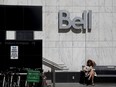 A woman reading outside a Bell Canada office in Toronto.