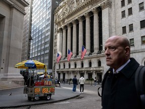 People pass by the New York Stock Exchange on Wall Street.