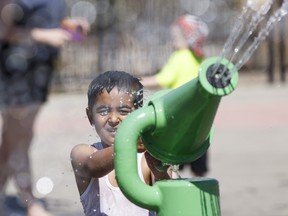 A kid plays in the spray park at Jackie Parker Park on a hot day in Edmonton.