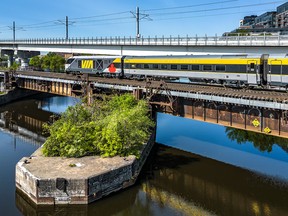A Via Rail Canada Inc. train passes over the Lachine Canal at the Peel Basin towards downtown Montreal.