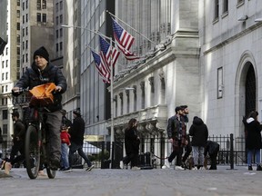 People pass the front of the New York Stock Exchange in New York, Tuesday, March 21, 2023.