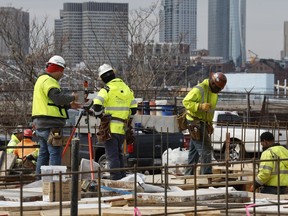 File - Construction workers prepare a recently poured concrete foundation, Friday, March 17, 2023, in Boston. On Thursday, the Labor Department reports on job openings and labor turnover for May.
